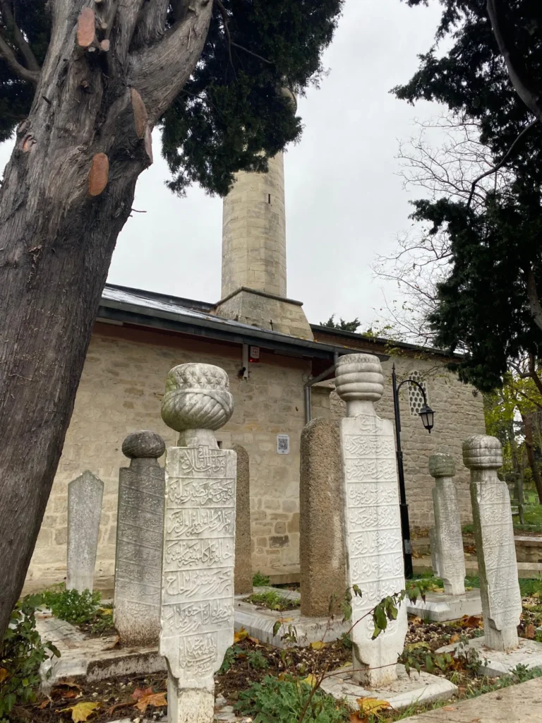 Baba Nakkaş Camii haziresindeki Osmanlı dönemine ait mezar taşları ve arka planda görülen minare